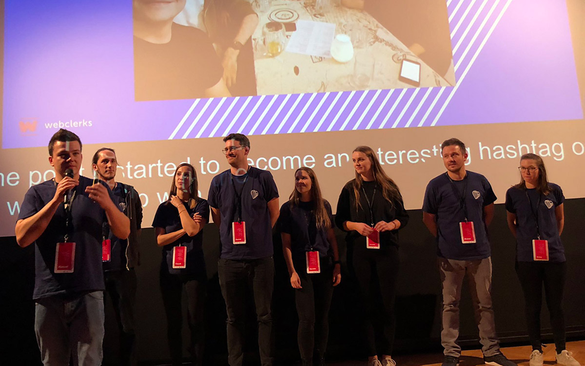 The webclerks team on stage in front of a screen